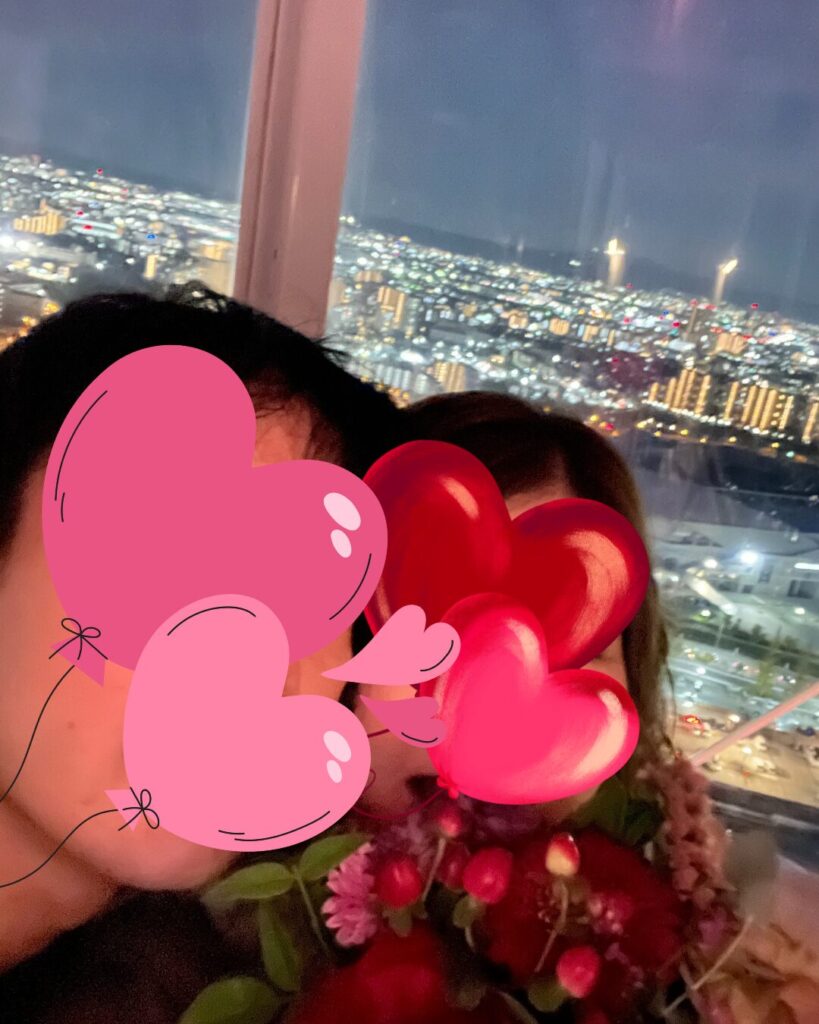 プロポーズの後、夜景を背景に記念写真