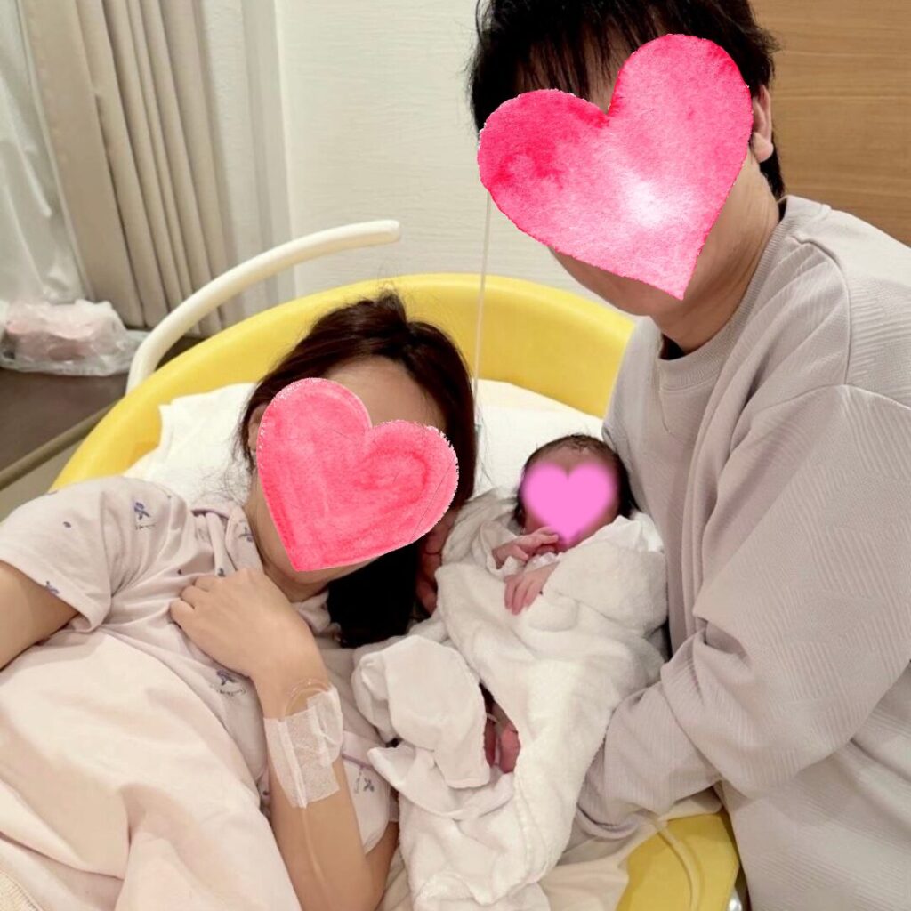 出産直後、赤ちゃんを囲んで寄り添うご夫婦と新生児の記念写真