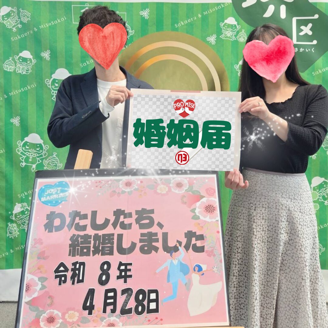 成婚退会されたお二人が、4月28日の入籍日に婚姻届を持って記念撮影している写真。背景には緑のパネルがあり、前には「わたしたち、結婚しました 令和8年4月28日」と書かれたボードが置かれている。お二人の顔はハートで隠され、幸せな入籍報告の雰囲気が伝わる画像。